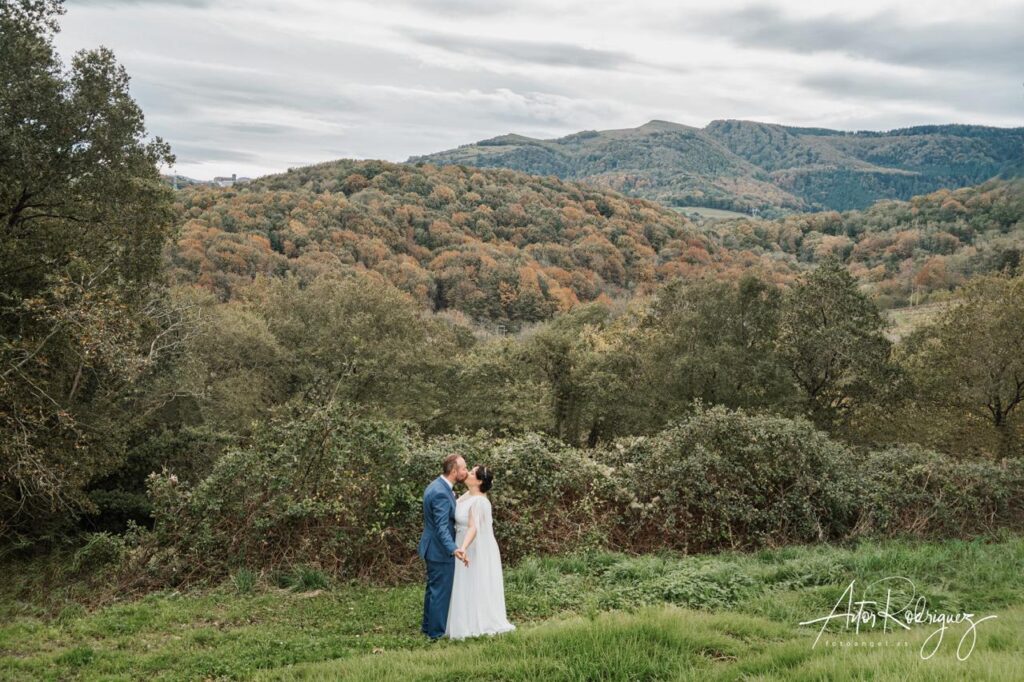 Novios besándose con un impresionante paisaje otoñal de fondo en las montañas cerca de Aia, Gipuzkoa.